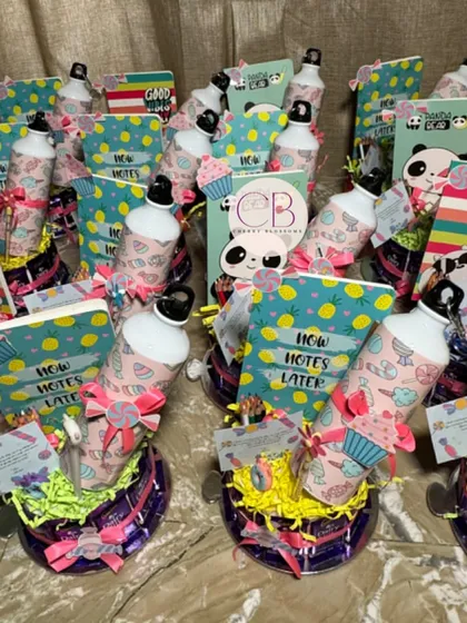 Our candy-themed return favours are so much fun to create. This unique arrangement features a base made of Dairy Milk chocolates, holding a variety of stationery items like a diary and a personalised sipper.