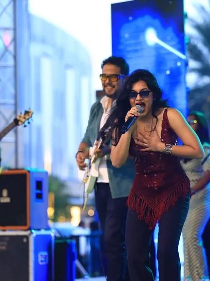 Singing my heart out on a large outdoor stage. This photo captures the passion and power of a Moksha All Stars performance in front of a big crowd.