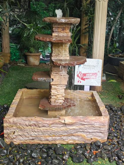 This fountain is made from natural, layered stone, giving it a unique and organic appearance.