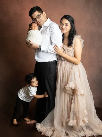 A candid moment where the older brother peeks out from behind his dad. Family shoots with toddlers are always full of fun and surprises.