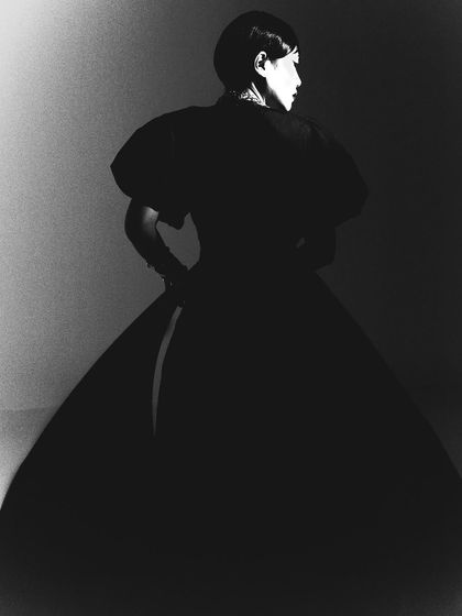A black and white silhouette from the same campaign. This artistic shot focuses entirely on the form and shape of the gown, creating a timeless and graphic image.
