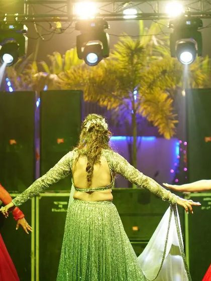 A beautiful shot from the back, showing the coordinated outfits and hairstyles of the bride's sisters during their performance.