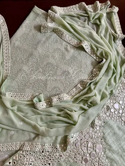A complete view of the mint green suit, showing the interplay between the dense Chikankari on the kurta and the bold mirrorwork on the palazzo and dupatta.