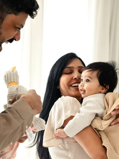The best moments are the unscripted ones. A father's playful gesture brings a smile to everyone's face in this candid family portrait, capturing the genuine joy of being together.