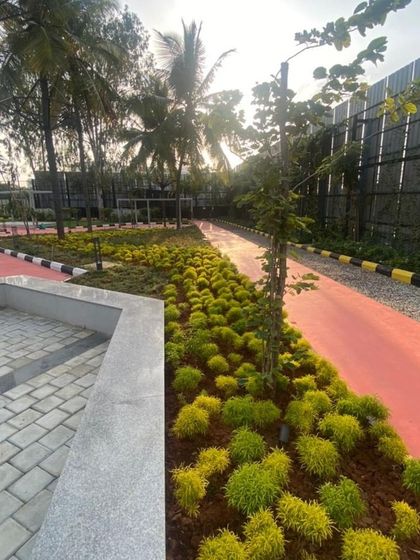 A duplicate image of the bright green foliage lining the red pathway, creating a strong visual contrast.