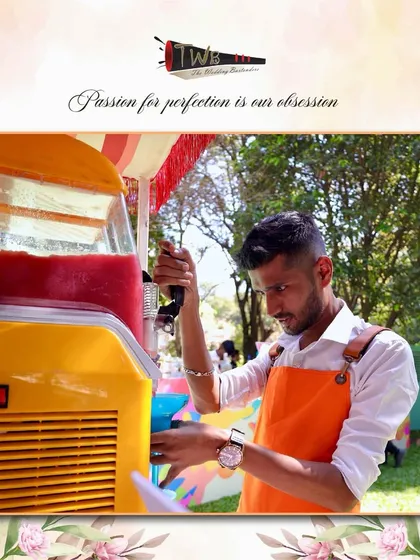 A bartender operates a slushie machine, a fun and popular addition to our brunch and daytime event packages.