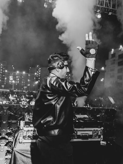 Waving to the crowd at a college show, with CO2 jets blasting in the background. This black and white photo captures the raw energy and connection of the moment.