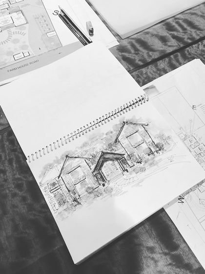 Beyond the beauty lies the journey. This image shows our process, from initial farmhouse sketches on a notepad to the detailed architectural plans that guide construction.