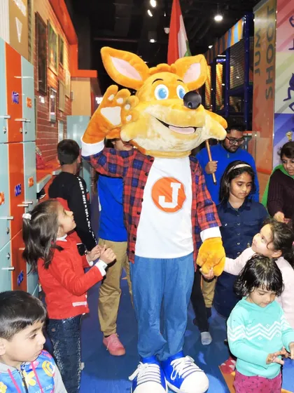 Our mascot, J the Fox, is surrounded by children eager to interact during the Independence Day parade.