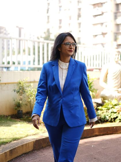 A photo of me walking in a blue suit. I'm fascinated by origin stories like Don Quixote, the first modern novel, which created a format we still use today.