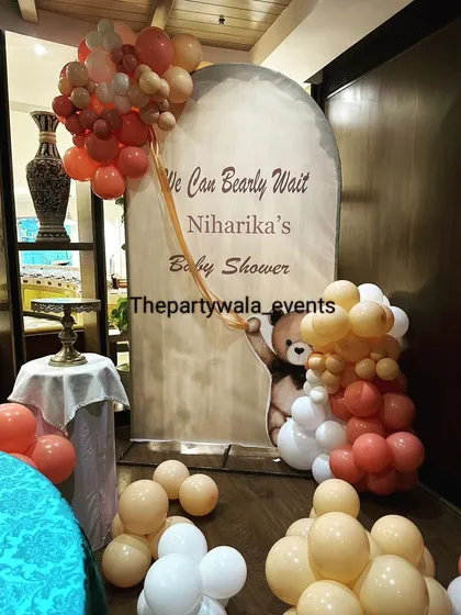 A "We Can Bearly Wait" teddy bear themed baby shower. The earthy tones of the balloons and the cute teddy bear backdrop create a warm and adorable atmosphere.