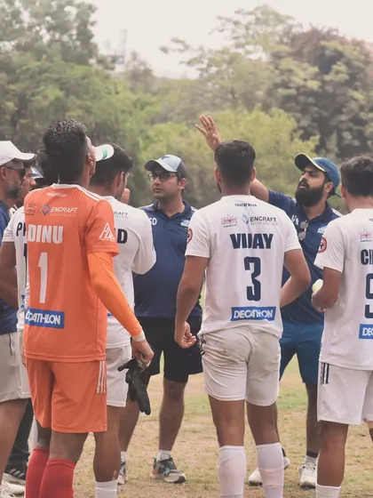 Strategy is everything. Here, our coaching staff delivers tactical instructions to the team during a break in play. Every player is focused, listening, and ready to execute the game plan.