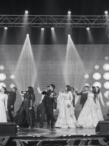 A black and white shot capturing the energy of a family finale. The entire group is in sync, creating a powerful and timeless image of togetherness.