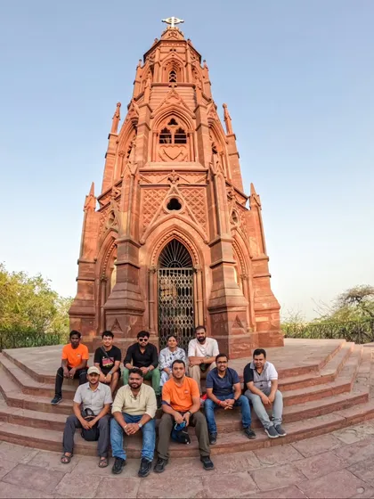Our group poses for a photo at the Mutiny Memorial on our Northern Ridge Walk. This tour is a deep dive into the history of the 1857 uprising, set against a backdrop of lush forest.