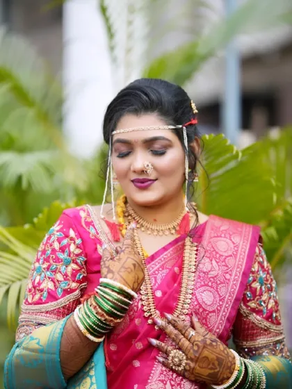 A close up of the bride's glowing makeup and traditional jewellery. The soft eyeshadow and bold lip color create a balanced and beautiful look.