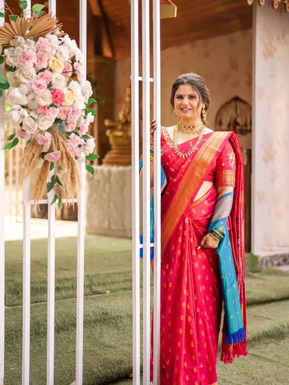 A full-length shot showcasing the beautiful pink saree and the soft, complementary makeup. The look is traditional, yet fresh and modern.