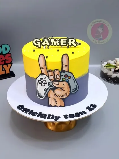 A cool painted cake for a gamer turning 13, with a hand holding a controller.