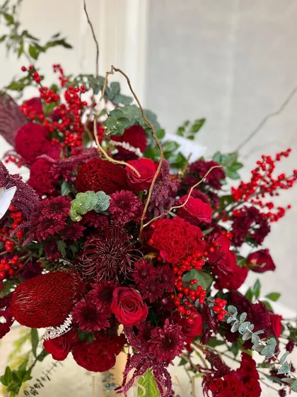 An observation, a vision, an arrangement. This piece is a celebration of red, featuring African Banksia, Pincushion, and Ilex berries imported from Holland, combined with the best locally available red blooms.