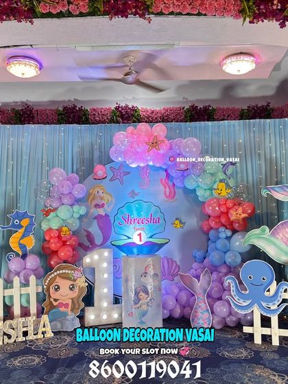 An enchanting "Under the Sea" mermaid theme for Shreesha's first birthday. This elaborate setup includes character cutouts, a custom name sign, and a beautiful backdrop with hanging floral elements.