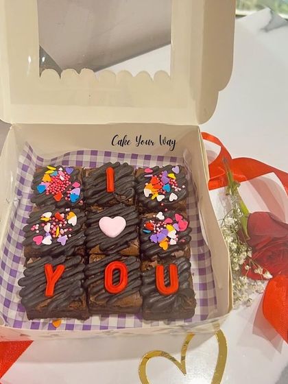 A simple and sweet Valentine's gift. This box of fudgy brownies spells out "I ❤️ YOU" with colorful sprinkles, making it a delicious way to express your feelings.