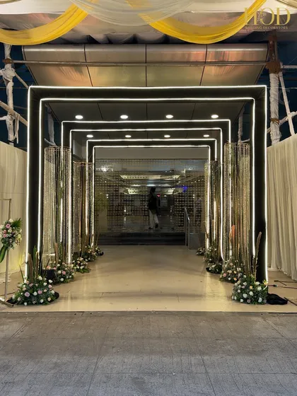 This modern and chic entrance uses clean lines and LED-lit arches to create a futuristic tunnel effect, perfect for a contemporary wedding reception or sangeet night.