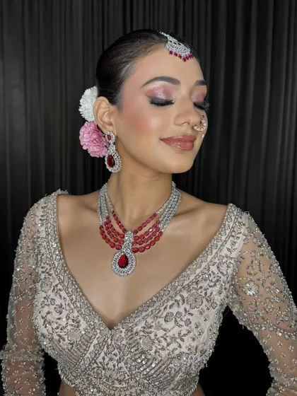A close-up of the Sagan bride, with her eyes closed to show off the beautiful pink and silver eyeshadow. The fresh flowers in her hair add a lovely touch.