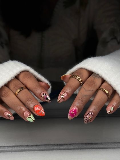 A full view of the mismatched artistic set. Each nail is a mini canvas, featuring different colors, hand-painted patterns, and gold accents.