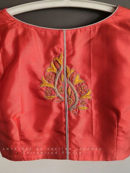 A close-up of the back embroidery motif on the custom silk blouse.