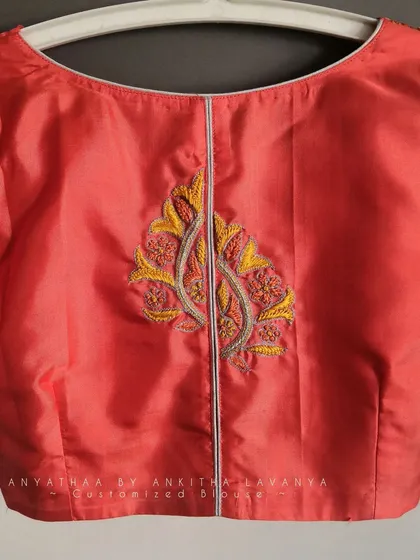 A close-up of the back embroidery motif on the custom silk blouse.