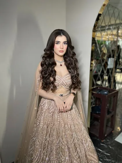 A full-length shot of Muskan, our beautiful engagement bride. The voluminous curls and shimmering lehenga create a truly show-stopping look.