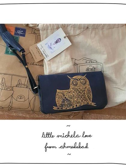 Kruti from Ahmedabad with her Little Michela wallet, customized with a Gond art owl motif in gold paint on Indus blue leather.