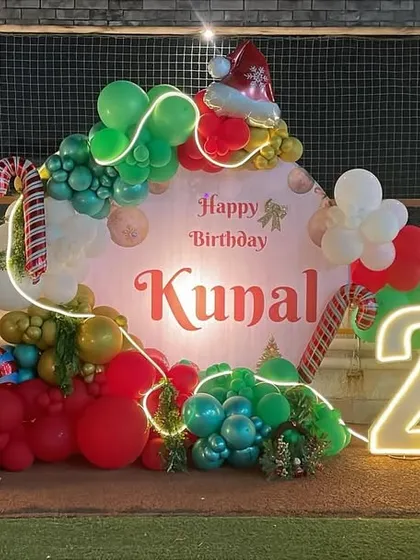 We love bringing holiday cheer to any celebration, like this Christmas-themed 28th birthday party. The decor features a festive balloon garland in red, green, and gold, a full balloon Christmas tree, and a cheerful Santa Claus foil balloon for that extra touch of magic.
