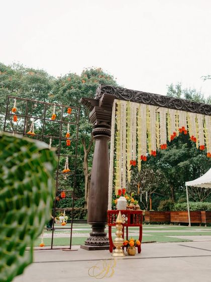 The entrance arch seen from a distance, highlighting its placement within the venue's green landscape and its role in setting a traditional tone for the wedding ceremony.
