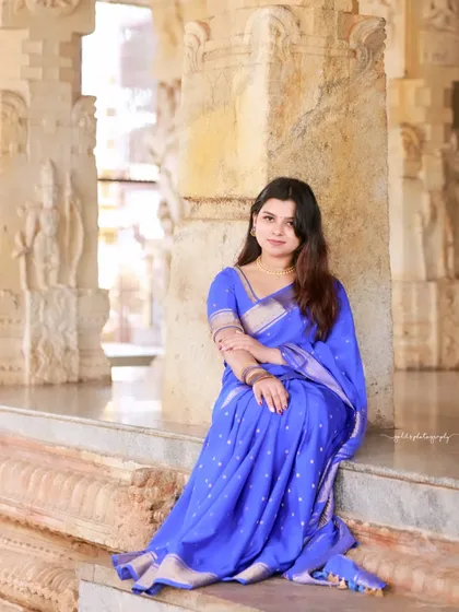 A simple and elegant portrait that highlights the vibrant color of the saree and the bride's natural beauty.