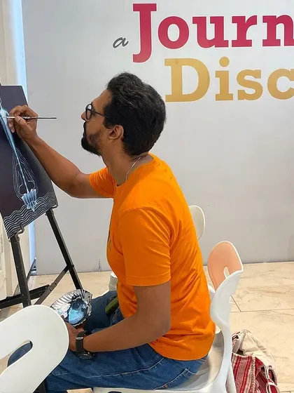 Another angle of me working on the yoga-themed painting, showing the initial layers and composition.