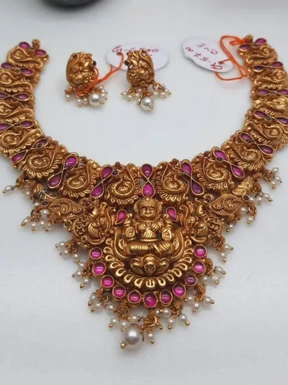 A stunning 92.5 silver gold-plated temple necklace. This choker-style piece features intricate peacock and floral motifs with pink stones and pearl drops, all centered around a goddess pendant.