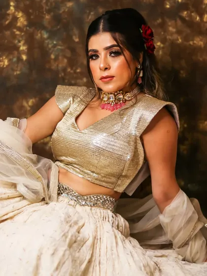 Elegant, bright, and beautiful. This full-length shot showcases a complete look with a golden glitter eye, soft waves, and a stunning white and gold lehenga.