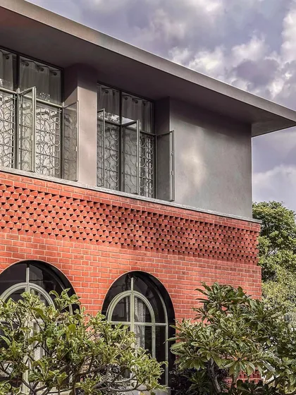 This exterior view of the Ferns Cottage highlights our focus on detailed craftsmanship. We combined classic arched windows on the ground floor with intricate brickwork and a modern, clean-lined upper level.