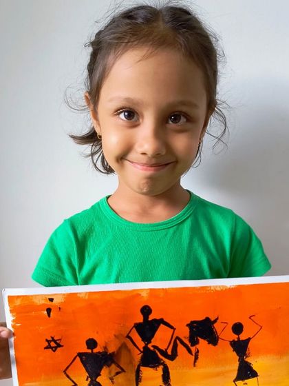 A student displays her wonderful Warli art painting, a traditional Indian folk art style we explore in our classes.