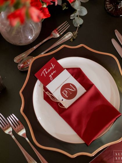 The elegant place setting at 'Le Rouge', featuring a custom thank-you note and monogrammed tag. These small details add a layer of personalization and sophistication.