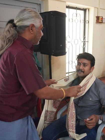A moment of respect during our Guruvandana ceremony, part of the Dasara Mahotsav. Here, a guru is honored with a traditional shawl.