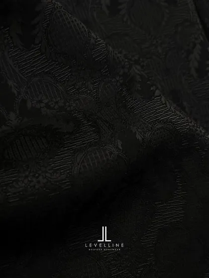 A sneak peek into our studio, showcasing the intricate black-on-black jacquard fabric and the design sketch for a client's special outfit.