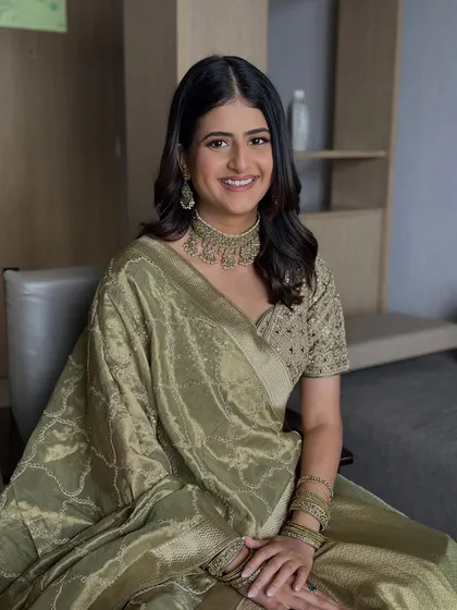 A seated portrait showing the complete look. The soft waves and natural makeup create an aura of effortless elegance for her engagement day.