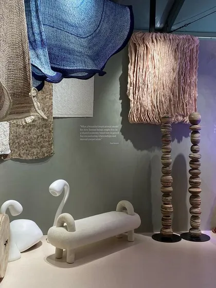 A display of sculptural objects and lighting from the 'Shroom' installation. The scene includes whimsical swan-like forms and lamps that resemble fungi, creating a magical atmosphere.