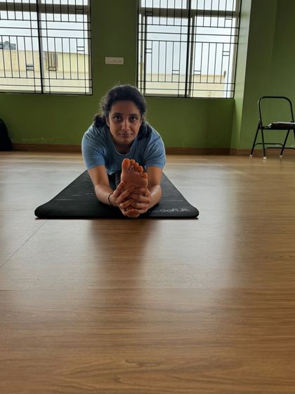 Holding the foot in a full front split forward bend. This level of flexibility is achieved through disciplined and intelligent sequencing, which we teach in our course.