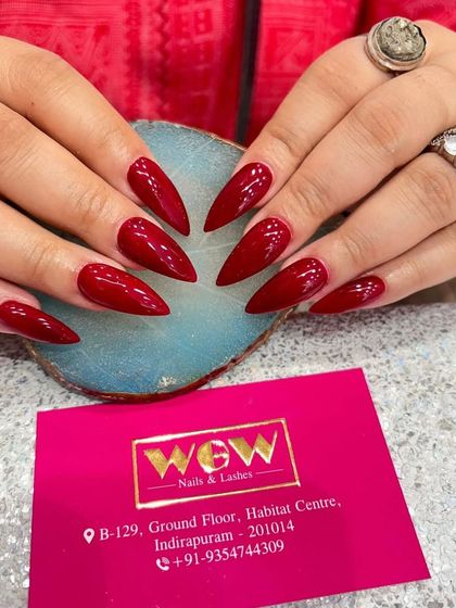 For those who love drama, these sharp, stiletto-shaped extensions in a deep, glossy red are the ultimate power move. We ensure every nail is sculpted to a perfect point for a fierce and confident look.