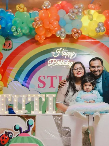 A lovely family photo in front of the vibrant Cocomelon themed backdrop for Stuti's first birthday. I ensure the colorful party decor is highlighted in your family portraits.