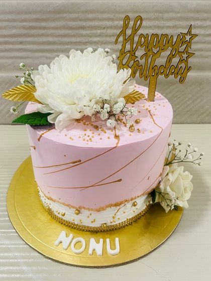 A pretty pink cake with delicate gold lines and fresh white flowers. A simple, elegant choice for any birthday.
