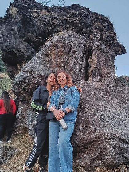 Posing by a unique rock formation on a group hike. Each retreat location is chosen for its natural beauty and spiritual energy, providing a stunning backdrop for your journey.