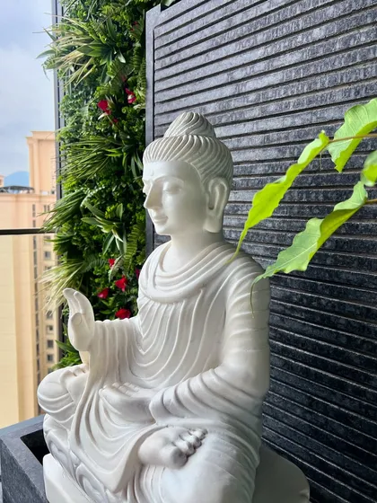 We cannot wait to feature this project. A close-up of a beautiful white marble Buddha statue set against a vertical garden, this detail brings a sense of peace and tranquility to the balcony space.